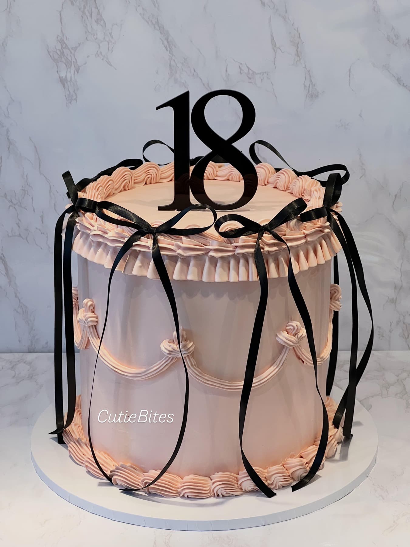 Blush pink vintage birthday cake with black ribbons and piped ruffles — Cutie Bites, Orpington