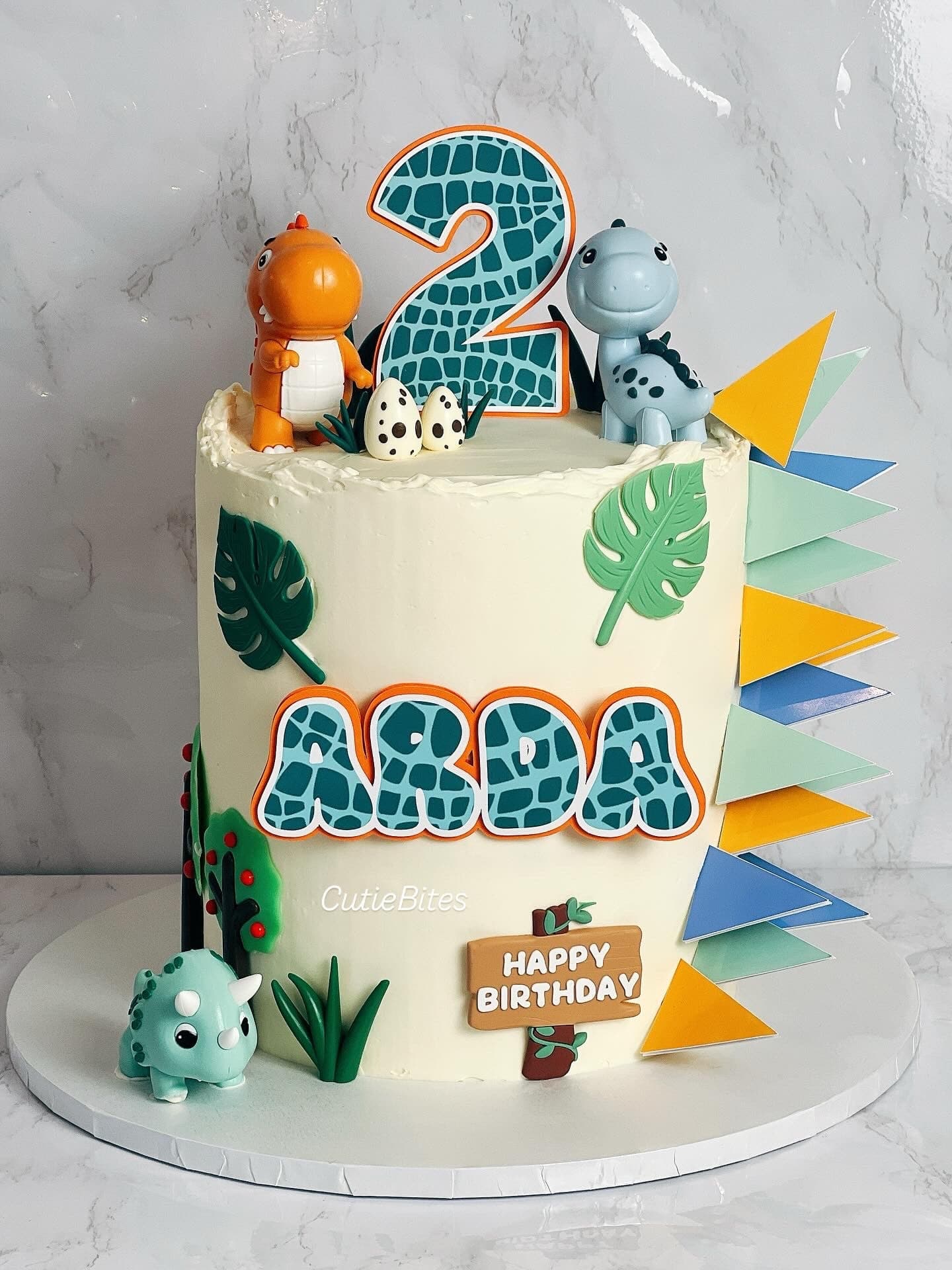 Dinosaur birthday cake with 3D dino toppers and colourful prehistoric theme