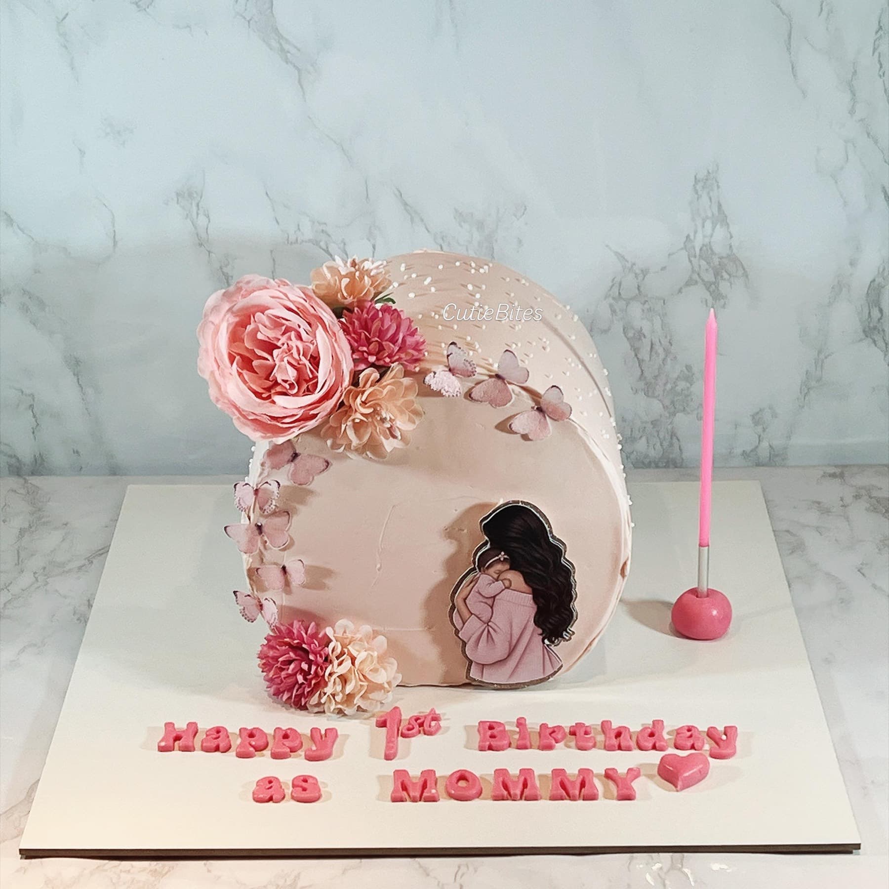 First birthday as mummy cake with blush flowers, butterflies and mum-and-baby topper — Cutie Bites, Orpington