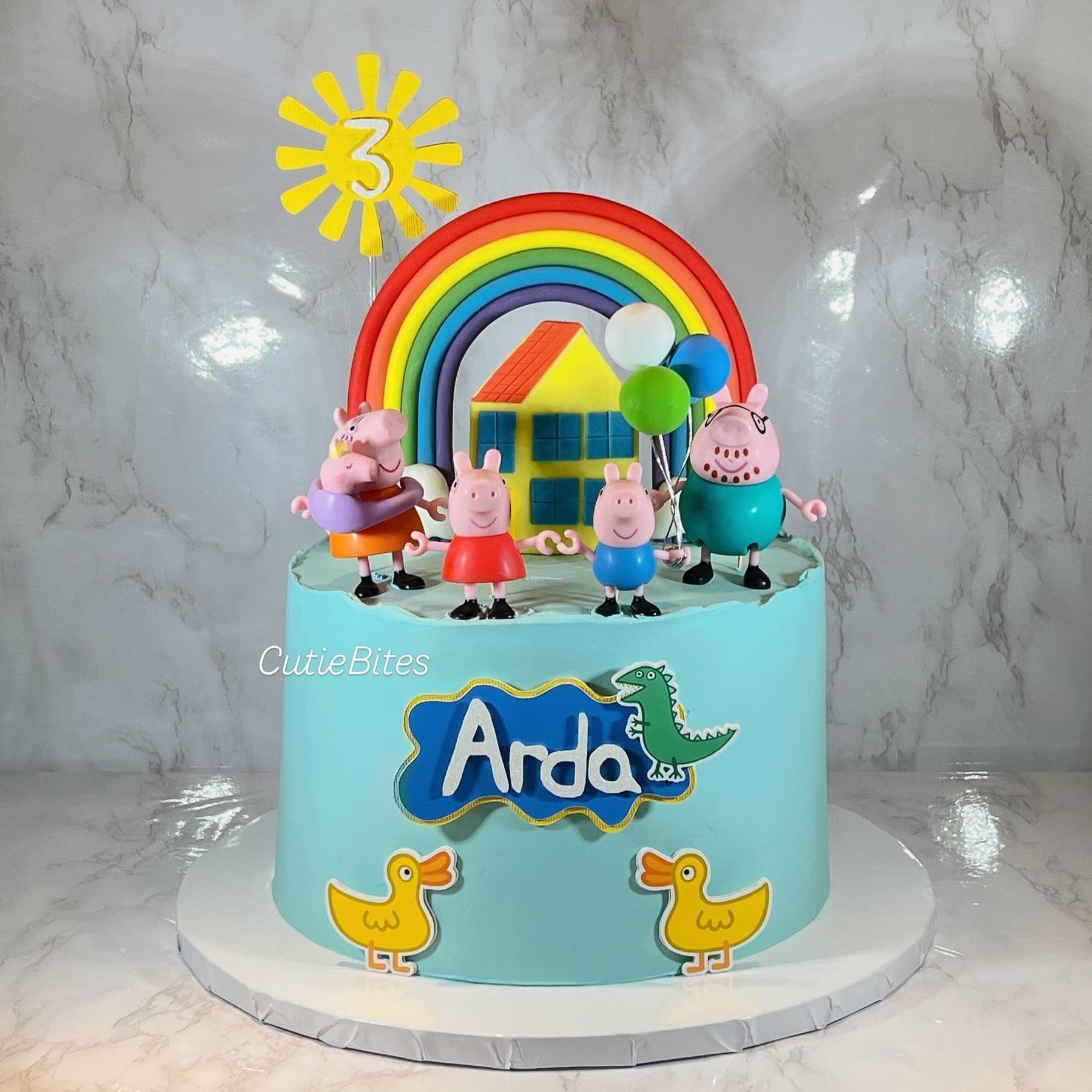 Peppa Pig garden birthday cake with rainbow, family, ducks and house — Cutie Bites, Orpington