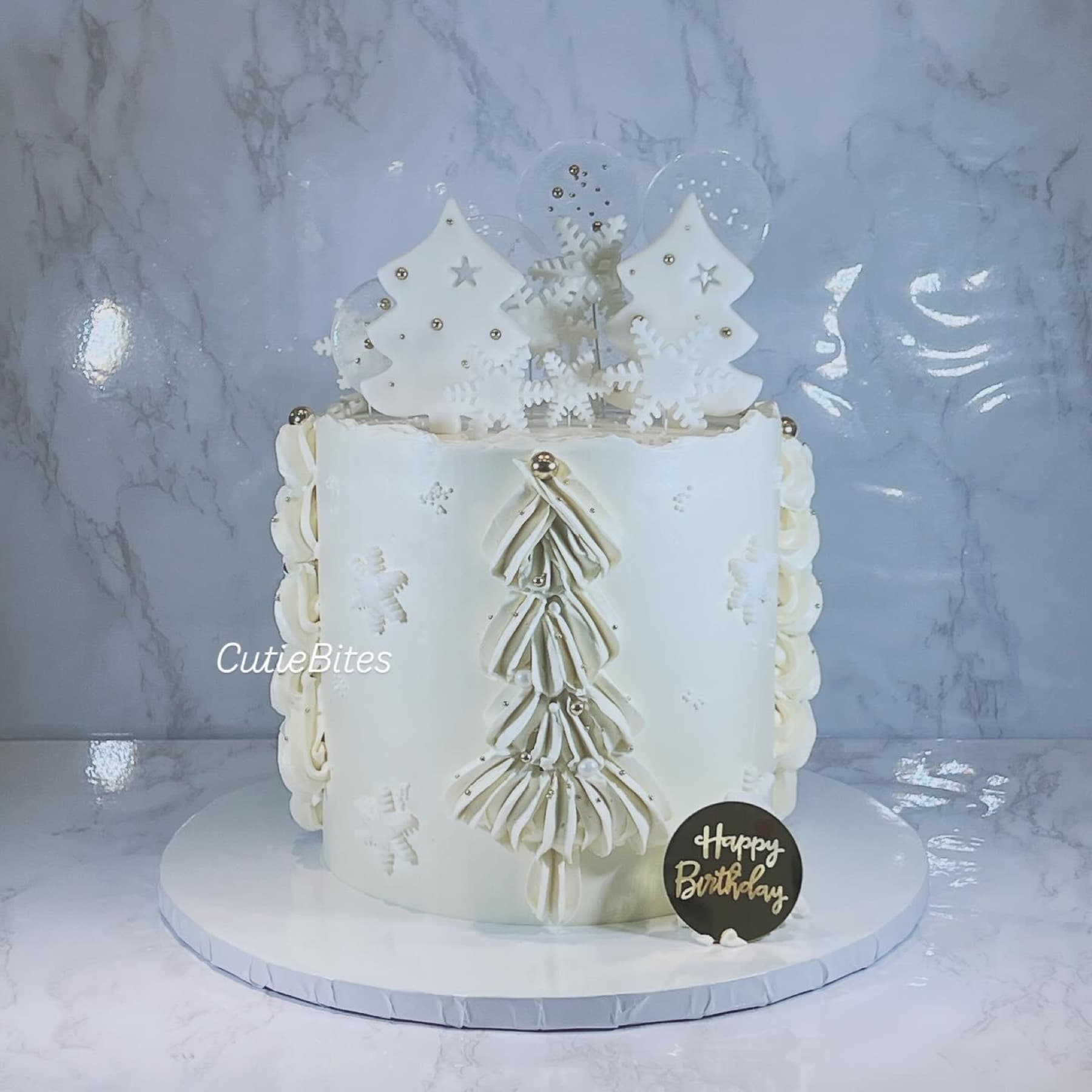 White winter wonderland birthday cake with piped Christmas tree and snowflakes — Cutie Bites, Orpington